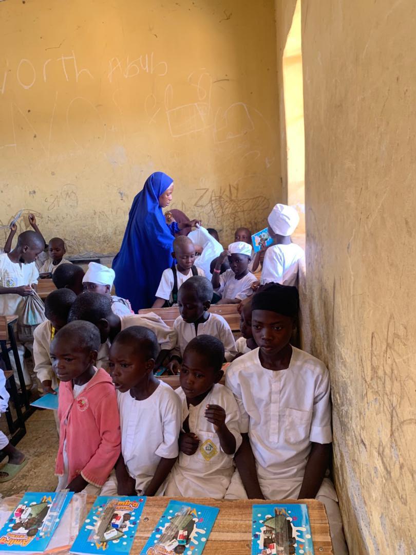 A volunteer handing out learning materials in class