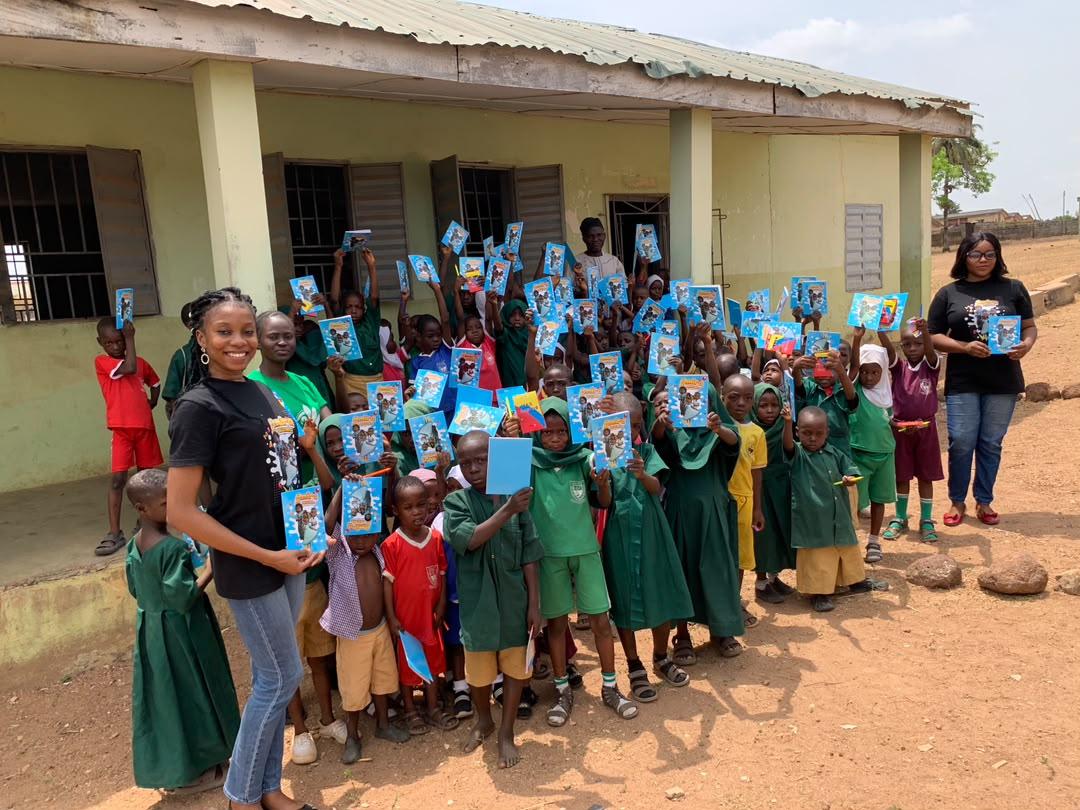 Volunteers with children showing off their new books